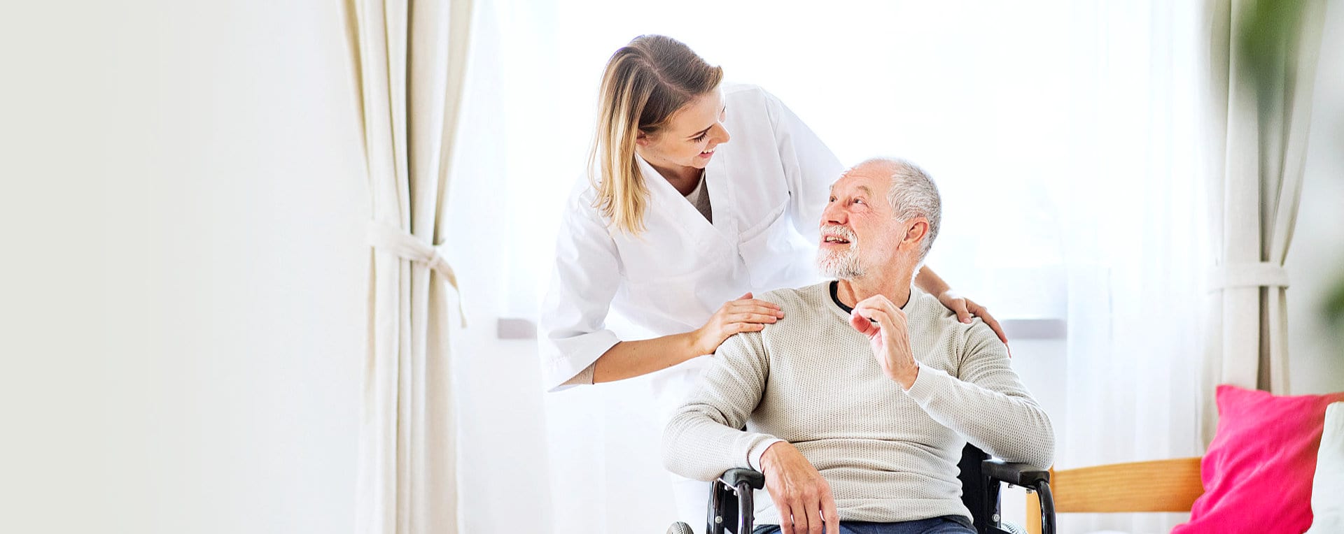 senior man and caregiver smiling each other